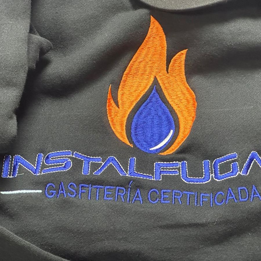 Chaqueta de trabajo con el logo Instalfugas Gasfitería Certificada bordado en naranja y azul